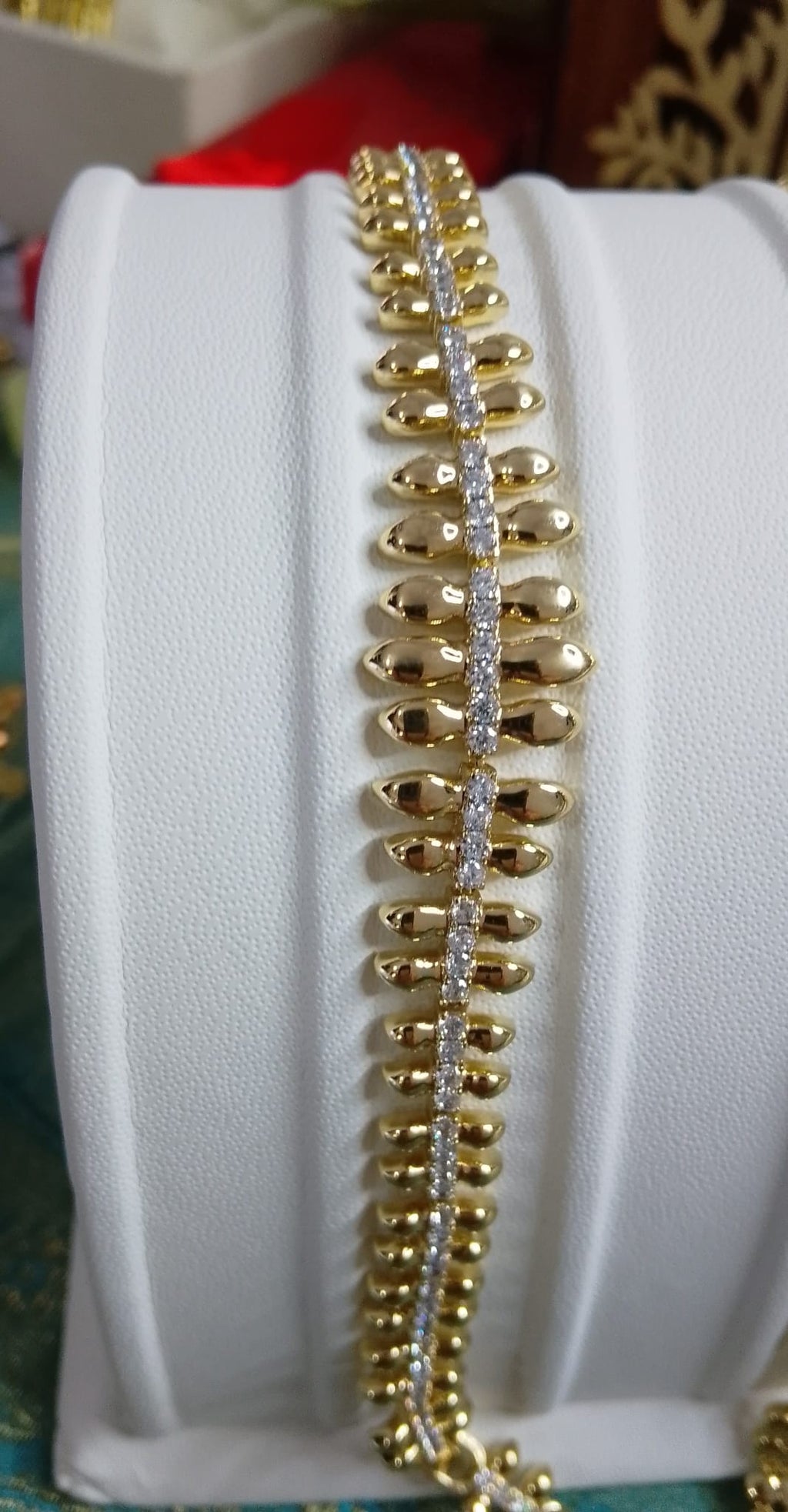 Bracciale elegante in acciaio inossidabile con zirconi e dettagli a foglia dorata.